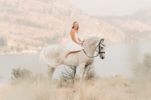woman on a white horse that benefits from Kelowna equine bodywork therapy