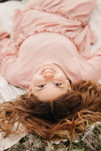 girl smiles lying down in Penticton after her counselling session