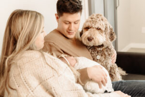 family looking at newborn with dog, Kelowna newborn photography